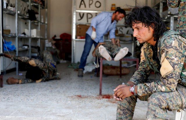 A Syrian Democratic Forces (SDF) fighter sit as medics treat his comrades injured by sniper fired by Islamic State militants in a field hospital in Raqqa, Syria June 28, 2017. REUTERS/Goran Tomasevic/File Photo      SEARCH "POY GLOBAL" FOR THIS STORY. SEARCH "REUTERS POY" FOR ALL BEST OF 2017 PACKAGES.    TPX IMAGES OF THE DAY
