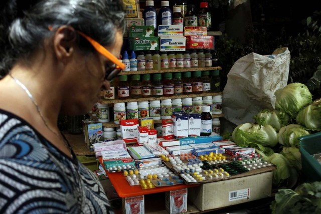 A woman walks past a fruit and vegetables stall selling medicines at a market in Rubio, Venezuela December 5, 2017. Picture taken December 5, 2017. REUTERS/Carlos Eduardo Ramirez
