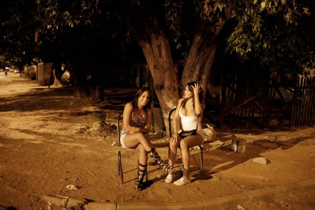Transsexuals Camila (R), 23, and Valeria, who left Venezuela nine months ago and are sex workers, wait for customers on a street in Boa Vista, Roraima state, Brazil November 18, 2017. Camila said she turns tricks and earns about $100 a night - enough to send food, medicine and even car parts to her family in Ciudad Bolivar. "Things are so bad in Venezuela I could barely feed myself," said Camila, who declined to give her last name. REUTERS/Nacho Doce SEARCH "VENEZUELAN MIGRANTS" FOR THIS STORY. SEARCH "WIDER IMAGE" FOR ALL STORIES.