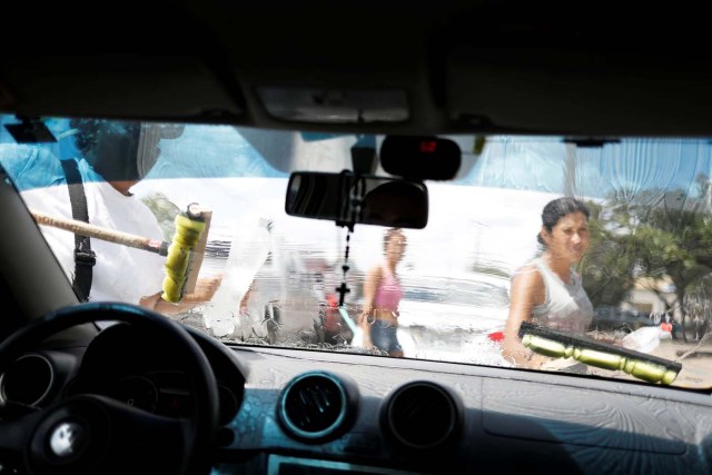 Venezuelans wash car windows at traffic lights in Boa Vista, Roraima state, Brazil November 17, 2017. REUTERS/Nacho Doce SEARCH "VENEZUELAN MIGRANTS" FOR THIS STORY. SEARCH "WIDER IMAGE" FOR ALL STORIES.