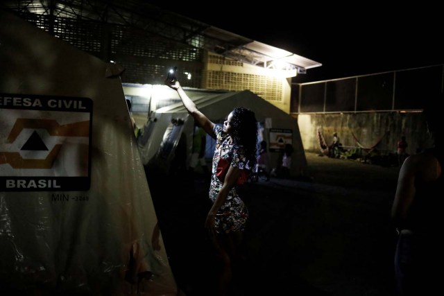 A Venezuelan woman takes a selfie next to a tent outside a gym which has turned into a shelter for Venezuelans and is run by Civil Defense with meals provided by Evangelical churches in Caimbe neighbourhood in Boa Vista, Roraima state, Brazil November 17, 2017. REUTERS/Nacho Doce SEARCH "VENEZUELAN MIGRANTS" FOR THIS STORY. SEARCH "WIDER IMAGE" FOR ALL STORIES.