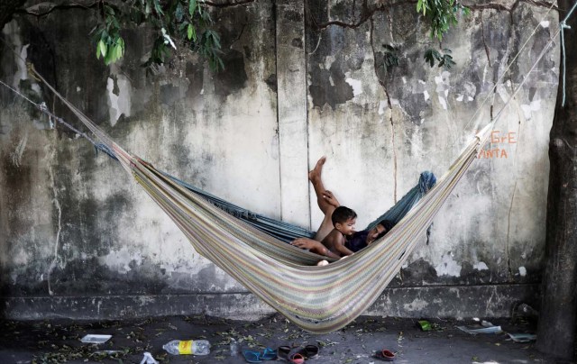 A family rests in a hammock outside a gym which has turned into a shelter for Venezuelans and is run by Civil Defense with meals provided by Evangelical churches in Caimbe neighbourhood in Boa Vista, Roraima state, Brazil November 17, 2017. REUTERS/Nacho Doce SEARCH "VENEZUELAN MIGRANTS" FOR THIS STORY. SEARCH "WIDER IMAGE" FOR ALL STORIES.