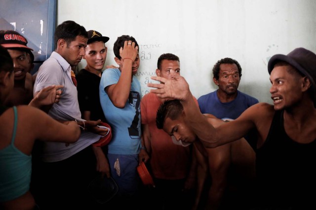 Venezuelans line up to receive food at a gym which has turned into a shelter for Venezuelans and is run by Civil Defense with meals provided by Evangelical churches in Caimbe neighbourhood in Boa Vista, Roraima state, Brazil November 17, 2017. REUTERS/Nacho Doce SEARCH "VENEZUELAN MIGRANTS" FOR THIS STORY. SEARCH "WIDER IMAGE" FOR ALL STORIES.
