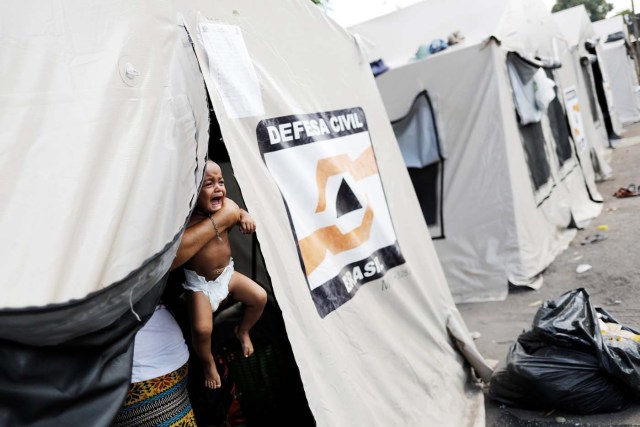 A Venezuelan woman holds her baby inside a tent outside a gym which has turned into a shelter for Venezuelans and is run by Civil Defense with meals provided by Evangelical churches in Caimbe neighbourhood in Boa Vista, Roraima state, Brazil November 17, 2017. REUTERS/Nacho Doce SEARCH "VENEZUELAN MIGRANTS" FOR THIS STORY. SEARCH "WIDER IMAGE" FOR ALL STORIES.