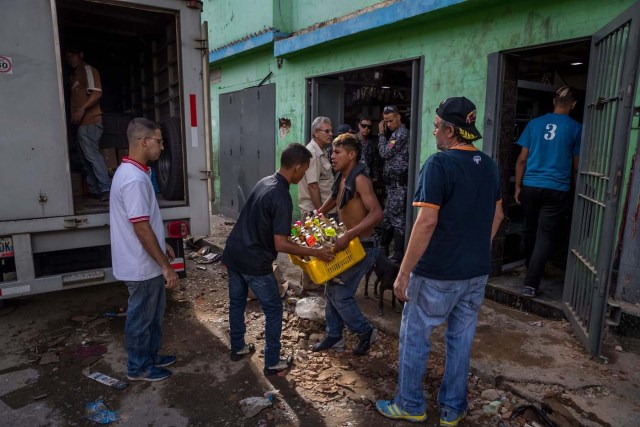 CAR106. CARACAS (VENEZUELA), 28/12/2018.- Un trabajador de una licorera que fue saqueada en horas de la madrugada en el sector La Vega saca productos del local comercial hoy, jueves 28 de diciembre del 2017, en Caracas (Venezuela). Durante la madrugada de este jueves se registraron en varios puntos de Venezuela protestas por la escasez de alimentos para completar el menú navideño, gas y agua, informaron hoy medios locales. EFE/MIGUEL GUTIÉRREZ
