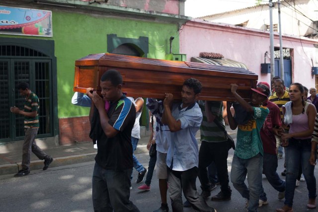 Relatives carry the coffin of Alexandra Conopoy, a pregnant 18 year-old killed during an incident over scarce of pork, according to local media, in Charallave, Venezuela January 1, 2018. Picture taken January 1, 2018. REUTERS/Adriana Loureiro
