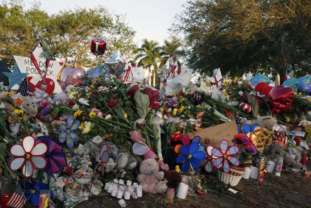 Flowers, candles and mementos sit outside one of the makeshift memorials at Marjory Stoneman Douglas High School in Parkland, Florida on February 27, 2018. Florida's Marjory Stoneman Douglas high school will reopen on February 28, 2018 two weeks after 17 people were killed in a shooting by former student, Nikolas Cruz, leaving 17 people dead and 15 injured on February 14, 2018. / AFP PHOTO / RHONA WISE