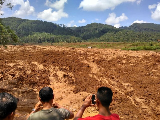 La gente toma fotos de un deslizamiento de tierra en Brebes, Indonesia el 22 de febrero de 2018, en esta imagen obtenida de las redes sociales. Aji Santoso / via REUTERS ESTA IMAGEN HA SIDO SUMINISTRADA POR UN TERCERO. CREDITO OBLIGATORIO. NO RESALES SIN ARCHIVOS