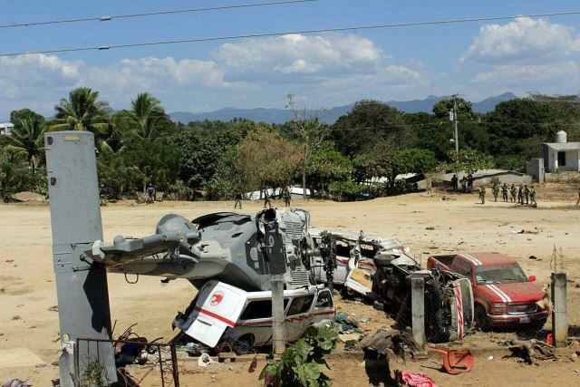 MEX22. PINOTEPA NACIONAL (MÉXICO), 17/02/2018.- Vista general del helicóptero accidentado en la comunidad de Jamiltepec hoy, sábado 17 de febrero de 2018, en Pinotepa Nacional (México). Trece personas murieron y 15 resultaron heridas en el accidente del helicóptero que trasladaba al secretario mexicano de Gobernación, Alfonso Navarrete, y el gobernador de Oaxaca, Alejandro Murat, quienes resultaron ilesos, a la localidad oaxaqueña de Jamiltepec. Al actualizar el balance de víctimas del accidente registrado poco antes del aterrizaje, la fiscalía de Oaxaca indicó hoy en un comunicado que "13 personas han fallecido", una de ellas en el hospital, mientras que "15 personas lesionadas han sido atendidas". EFE/Carlos Edil Torres García