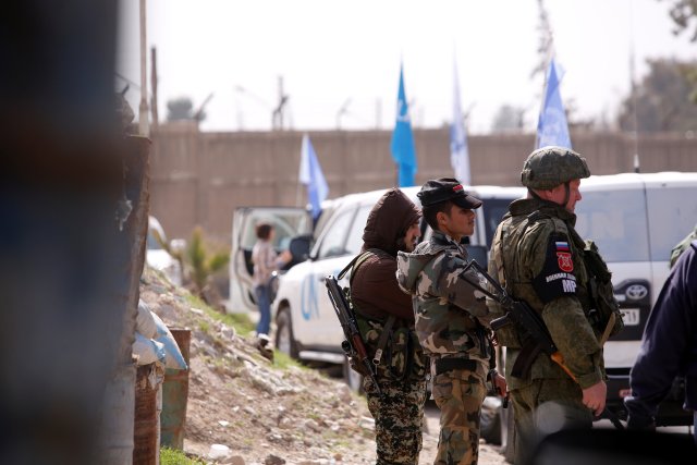 El convoy de ayuda de las Naciones Unidas asegurado por soldados sirios y rusos se ve en un puesto de control cerca del campamento de Wafideen en Damasco, Siria, el 5 de marzo de 2018. REUTERS / Omar Sanadiki