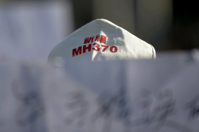 Un familiar de un pasajero del vuelo MH370 de Malaysia Airlines que desapareció en 2014 sostiene una pancarta durante una reunión frente a la Embajada de Malasia en el segundo aniversario de la desaparición de MH370, en Beijing, China, el 8 de marzo de 2016. REUTERS / Damir Sagolj / Foto de archivo