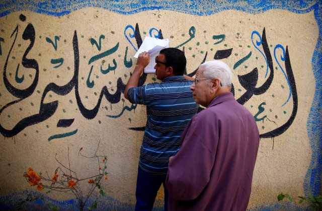 An Egyptian man looks at the voters name list outside a polling station during the presidential election in Cairo, Egypt, March 26, 2018. REUTERS/Amr Abdallah Dalsh