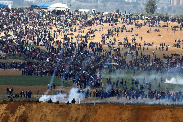 Israeli soldiers shoot tear gas from the Israeli side of the Israel-Gaza border, as Palestinians protest on the Gaza side of the border, March 30, 2018. REUTERS/Amir Cohen