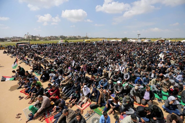 Palestinians attend Friday prayer during a tent city protest along the Israel border with Gaza, demanding the right to return to their homeland, the southern Gaza Strip March 30, 2018. REUTERS/Ibraheem Abu Mustafa