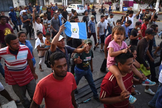 A migrant -alongside other Central Americans taking part in a caravan called "Migrant Viacrucis" towards the United States- holds a Guatemalan national flag during a march to protest against US President Donald Trump's policies in Matias Romero, Oaxaca State, Mexico, on April 3, 2018. The hundreds of Central Americans in the "Way of the Cross" migrant caravan have infuriated Trump, but they are not moving very fast -- if at all -- and remain far from the US border. As Trump vowed Tuesday to send troops to secure the southern US border, the caravan was camped out for the third straight day in the town of Matias Romero, in southern Mexico, more than 3,000 kilometers (1,800 miles) from the United States. / AFP PHOTO / VICTORIA RAZO