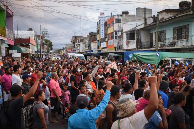 Central American migrants taking part in a caravan called "Migrant Viacrucis" towards the United States march to protest against US President Donald Trump's policies as they remain stranded in Matias Romero, Oaxaca State, Mexico, on April 3, 2018. The hundreds of Central Americans in the "Way of the Cross" migrant caravan have infuriated Trump, but they are not moving very fast -- if at all -- and remain far from the US border. As Trump vowed Tuesday to send troops to secure the southern US border, the caravan was camped out for the third straight day in the town of Matias Romero, in southern Mexico, more than 3,000 kilometers (1,800 miles) from the United States. / AFP PHOTO / VICTORIA RAZO