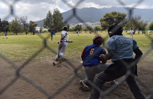 Venezuelan immigrants play softball during the inauguration of the Pichincha League Softball Championship, at Parque Bicentenario, in Quito on March 18, 2018. The increase in the number of Venezuelan immigrants in Ecuador leaded to growth of the softball league from four to 16 teams in the last years, with some 450 players in total. / AFP PHOTO / Rodrigo BUENDIA / TO GO WITH AFP STORY BY PAOLA LOPEZ