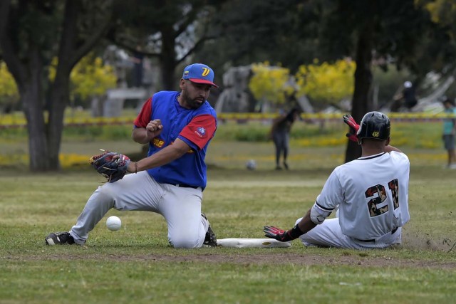 Venezuelan immigrants play softball during the inauguration of the Pichincha League Softball Championship, at Parque Bicentenario, in Quito on March 18, 2018.   The increase in the number of Venezuelan immigrants in Ecuador leaded to growth of the softball league from four to 16 teams in the last years, with some 450 players in total.  / AFP PHOTO / Rodrigo BUENDIA / TO GO WITH AFP STORY BY PAOLA LOPEZ