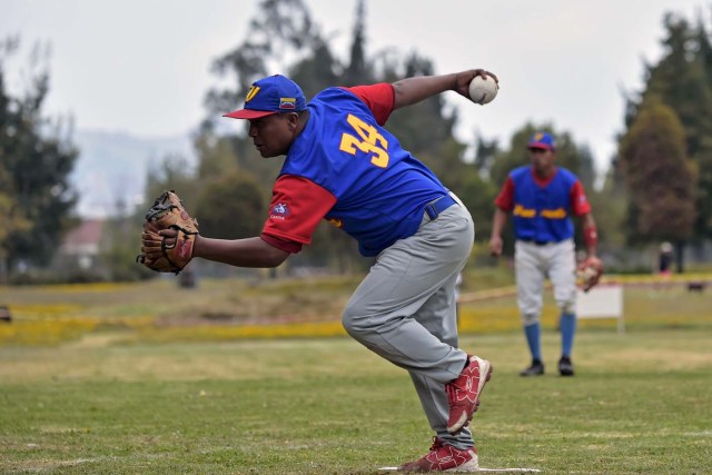 Venezuelan immigrants play softball during the inauguration of the Pichincha League Softball Championship, at Parque Bicentenario, in Quito on March 18, 2018. The increase in the number of Venezuelan immigrants in Ecuador leaded to growth of the softball league from four to 16 teams in the last years, with some 450 players in total. / AFP PHOTO / Rodrigo BUENDIA / TO GO WITH AFP STORY BY PAOLA LOPEZ