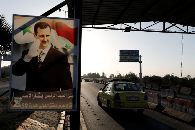 A poster of Syrian President Bashar al-Assad is seen on the main road to the airport in Damascus, Syria April 14, 2018. REUTERS/Omar Sanadiki