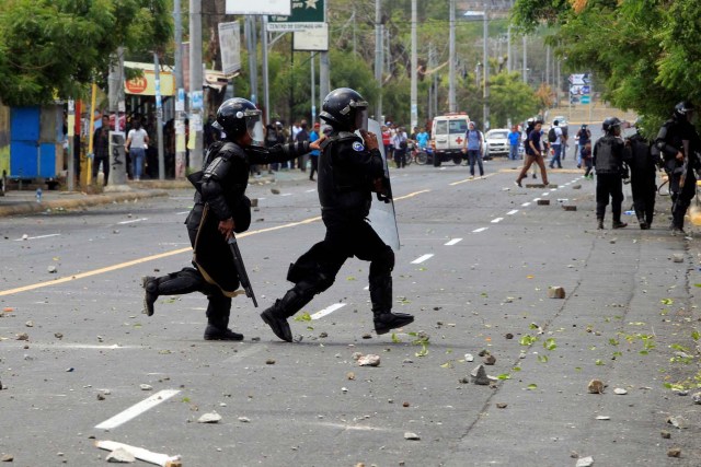 Un policía antidisturbios arroja una piedra contra los estudiantes universitarios durante una protesta contra las reformas que implementan cambios en los planes de pensiones del Instituto Nicaragüense de Seguridad Social (INSS) en Managua, Nicaragua, abril 19,2018.REUTERS / Oswaldo Rivas