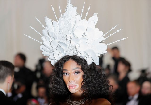 La modelo Winnie Harlow con un tocado blanco con flores de porcelana. REUTERS/Carlo Allegri