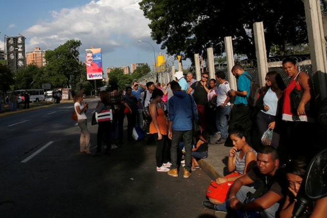 Los carteles de campaña del presidente venezolano, Nicolás Maduro, para las elecciones presidenciales de 2018 se ven en la calle mientras la gente espera un autobús en Caracas, Venezuela, el 11 de mayo de 2018. Fotografía tomada el 11 de mayo de 2018 REUTERS / Carlos Jasso