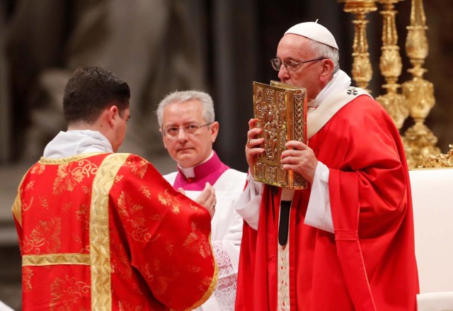 Pope Francis kisses the Book of the Gospels as he leads a Mass of Pentecost at Saint Peter's Basilica at the Vatican, May 20, 2018. REUTERS/Remo Casilli