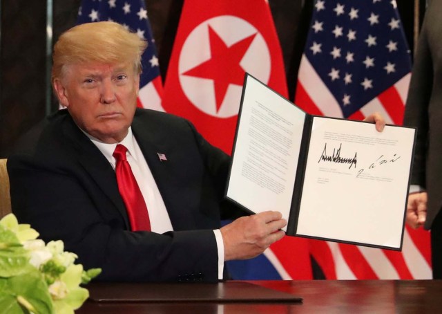 El presidente estadounidense, Donald Trump, muestra el documento, que él y el líder norcoreano Kim Jong Un firmaron reconociendo el progreso de las conversaciones y prometieron mantener el impulso, después de su cumbre en el Hotel Capella en la isla Sentosa en Singapur el 12 de junio de 2018. REUTERS / Jonathan Ernst