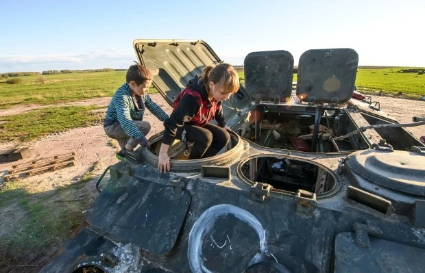 Diversión en el lugar más sombrío: Niños valientes juegan con un tanque ruso incendiado (FOTOS)