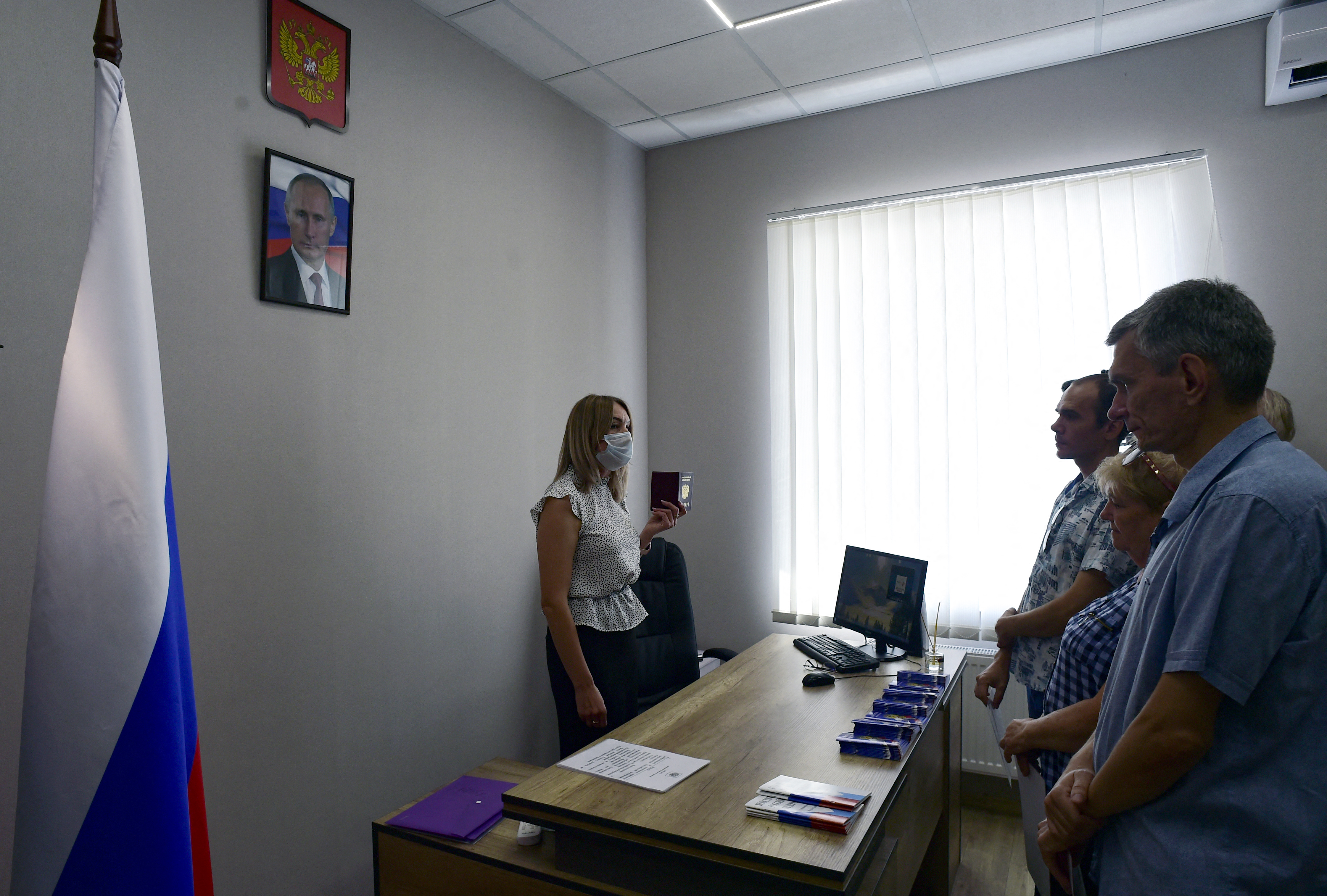 Ucranianos devastados por la guerra comienzan a aceptar pasaportes rusos y “rendirse” ante la figura de Putin