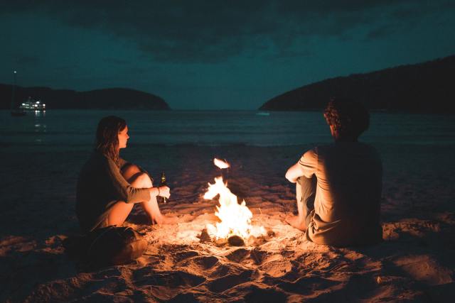 pareja fuego fogata playa noche