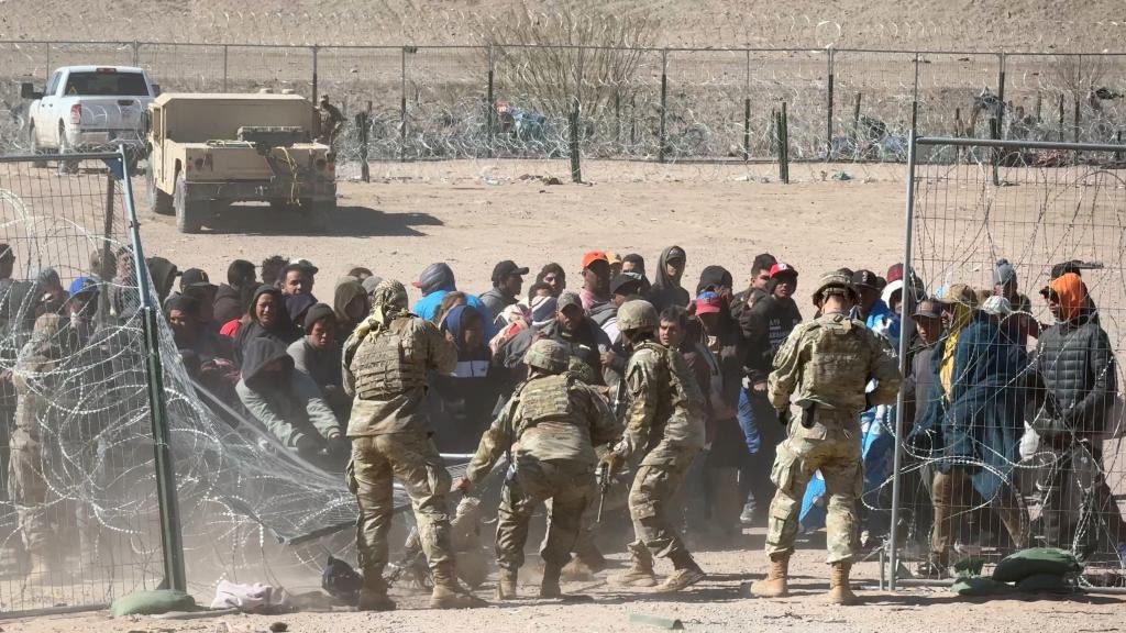 Caos en la frontera sur: un centenar de inmigrantes rompen alambre de púas y derriban a guardias para cruzar (VIDEO)